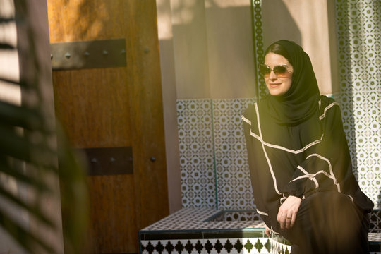 Arab woman sitting outdoors.