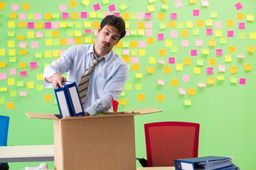 Man collecting his stuff after redundancy in the office with man