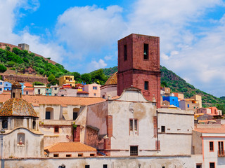 view of the colorful houses and castle in the background in the city of Bosa