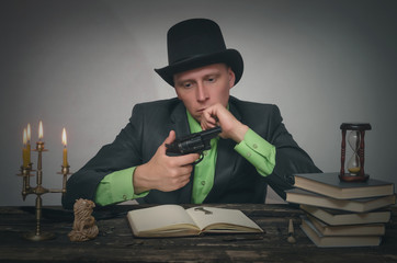 Pensive detective spy agent holding in hands a gun and thinking. Detective or spy agent or police...