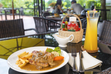 Juicy grilled pork steak and potatoes vegetables for restaurant menus healthy eating homemade with mushroom sauce on wooden table.