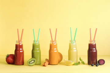 Fototapeta na wymiar Composition of healthy and useful colorful vegetable juices and smoothies with chia and flax seeds in glass bottles, set on the yellow background, copy space