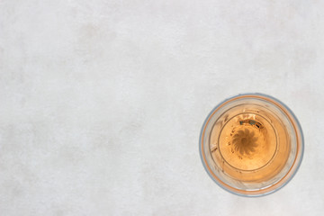 Glass of rose pink wine on light grey background