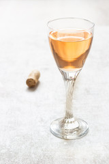 Glass of rose pink wine on light grey background