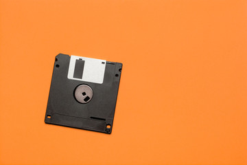 floppy data storage diskette on orange background with copy space