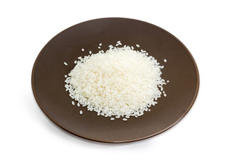Uncooked white rice on the brown dish on white background