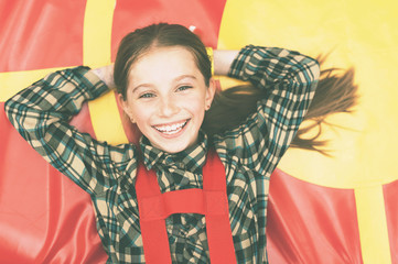 smiling joyful girl lying on colorful trampoline with instagram filter