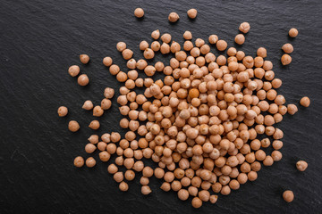 uncooked chickpeas on a dark stone background