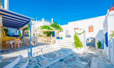 Outdoor cafe with wooden furnitures on a sunny square in Lefkes, Greece