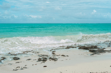 Small waves from a storm in the Indian ocean. Clean water runs on the light sand of the beach