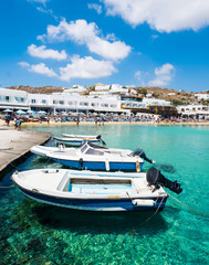 Several boats at pier beside the beach in bright sunny day