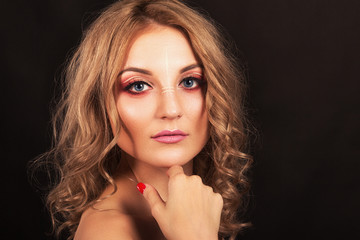 Studio portrait. Beautiful girl with evening make-up on a black background