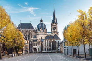 Wallpaper murals Historic building German cathedral in Aachen during fall with yellow leafs at trees with blue sky