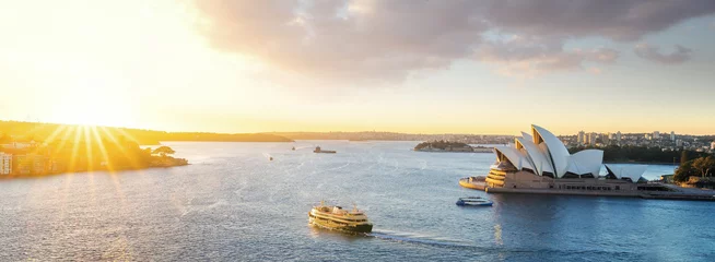 Fototapeten Stadtbild von Sysney-Hafen mit morgendlichem Sonnenaufgang und Boot im Meer © anekoho