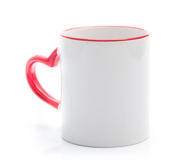 White cup with red rim and handle in heart shape isolated on a white background