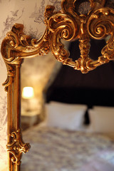 reflection of a bed in a gold vintage mirror
