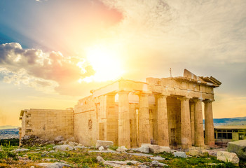 Glowing sun rays illuminate ancient Erechtheum temple ruins, Acropolis, Athens, Greece
