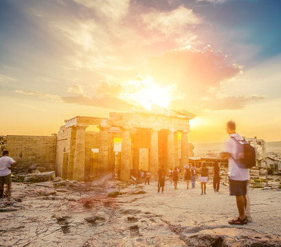 People in motion blur walking around the ruins of Parthenon temple in Athens at sunset, Greece