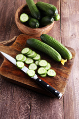 Fresh and sliced cucumbers. Sliced cucumbers on a cutting board. © beats_