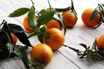 Tangerines with leaves on wooden background. Mandarins Rustic style