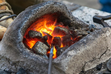 А red-hot piece of iron in a forge furnace, flames of fire, blacksmithing