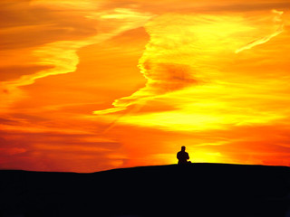 Fototapeta premium Man on sunset background and orange sky