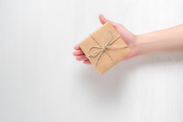 hand of a young girl holding a gift box on a white background