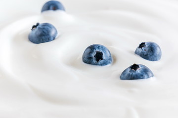 Organic yogurt and fresh berries blueberries, texture, background. Flat lay, top view, copy space 