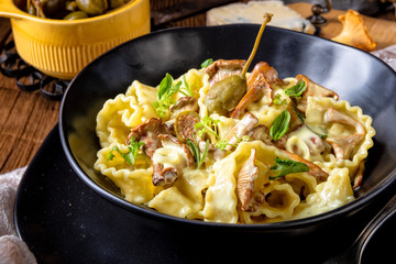 Reginette noodles in cream sauce with fresh chanterelles and capers