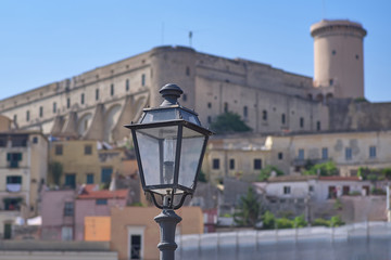 Fototapeta na wymiar An old street lamp on the background of an old fortress