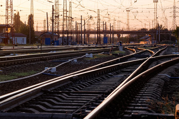 Fototapeta na wymiar Railway pointwork, railway tracks on the station at summer sunset. Transportation
