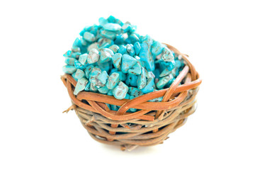 Fototapeta na wymiar Pile stones of raw Turquoise in small wooden nest on a white background