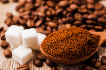 preparation scrub of ground coffee. ground and whole coffee beans.coffee beans.Roasted coffee beans goals.spoon ground coffee, sugar cubes