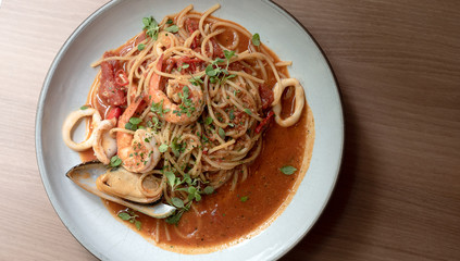 Seafood spaghetti with shrimp, mussels and squid White plate on the table