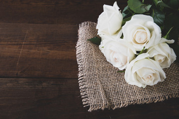 Bunch of beautiful white roses on wooden background
