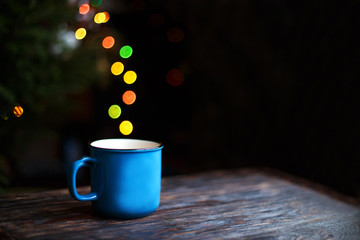 a cup on the wooden background . Christmas bokeh