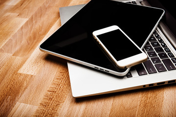 keyboard with phone and tablet pc on wooden desk