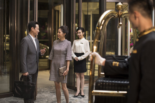 Confident business people talking in hotel lobby