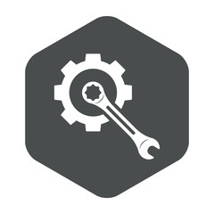 Icono plano engranaje con llave en centro en hexagono gris