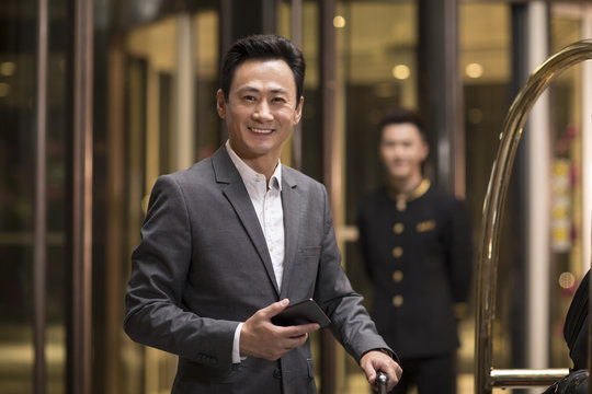 Cheerful businessman holding a smart phone