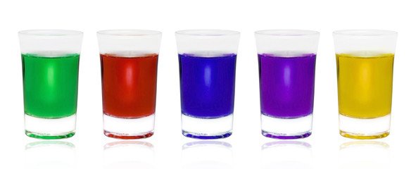Different color drinks in glasses on white background. Five  glasses with some colored liquid and one is different. Glass with green absinthe. Set a small shot glass with color liquid