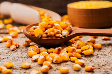 a bowl of corn is on a wooden table