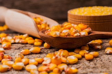 a bowl of corn is on a wooden table