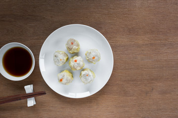 top view of pork shumai served with soy sauce on wooden table. popular chinese food appetizer