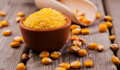 a bowl of corn is on a wooden table