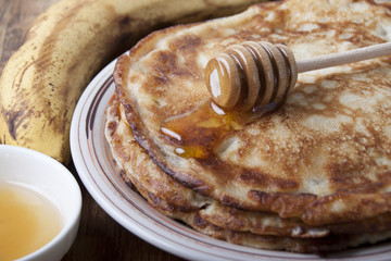 Banana pancakes with honey on a plate