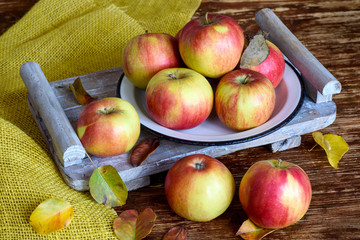 Red yellow apples and autumn leaves on the table