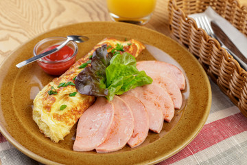Delicious breakfast. Fried omlette with sliced ham close up