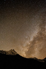 Sky full of stars and Milky Way. Nightime scene with himalayan mountains and starry sky at in Nepal, Manaslu, Himalayas. Night landscape with bright milky way. Snowy mountains at night.