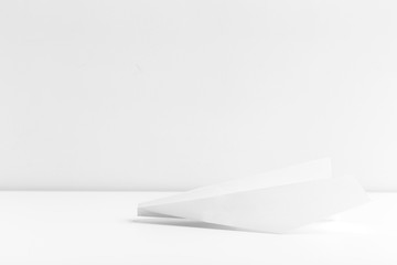 Flat lay of white paper plane on white color background